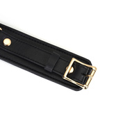 Wykwintne kajdanki na uda z licowej ścisłej skóry bydlęcej w kolorze głębokiej czerni z okuciami  z metalu w kolorze złota rozmiar M/L obwód max 81 cm