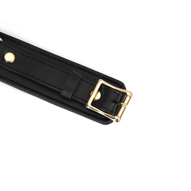 Wykwintne kajdanki na uda z licowej ścisłej skóry bydlęcej w kolorze głębokiej czerni z okuciami  z metalu w kolorze złota rozmiar M/L obwód max 81 cm